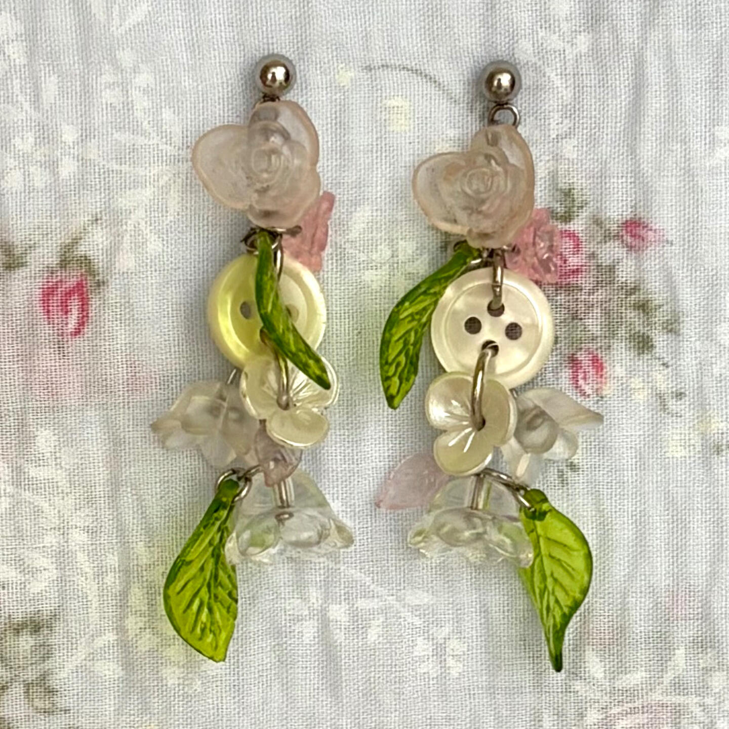 swoon over this botanical earring pair. featuring a variety of glass + acrylic flowers, acrylic leaves, mother of pearl buttons, and stainless steel hardware.