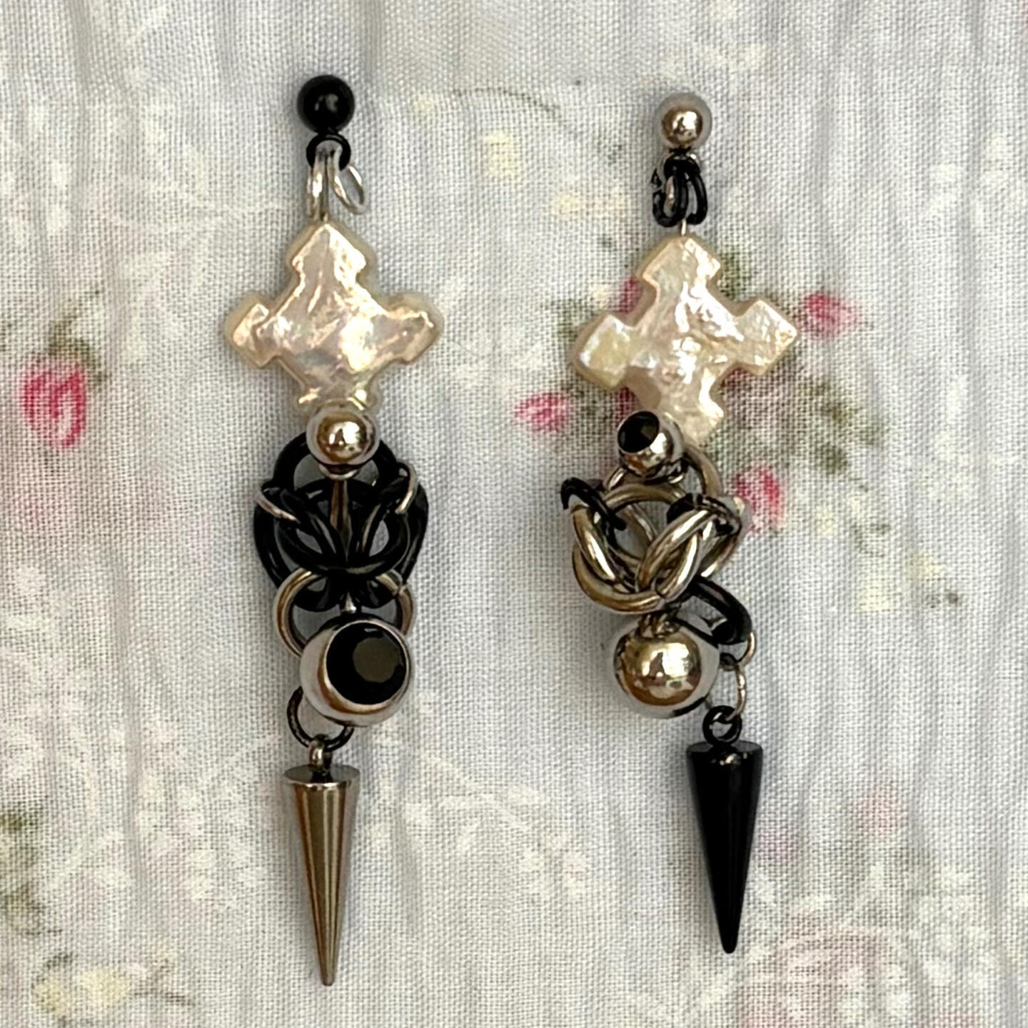 sometimes the saboteur is within us. twisted, tangled, almost indecipherable. constructed using freshwater pearl crosses, mismatched bellybutton jewellery, and stainless steel hardware.