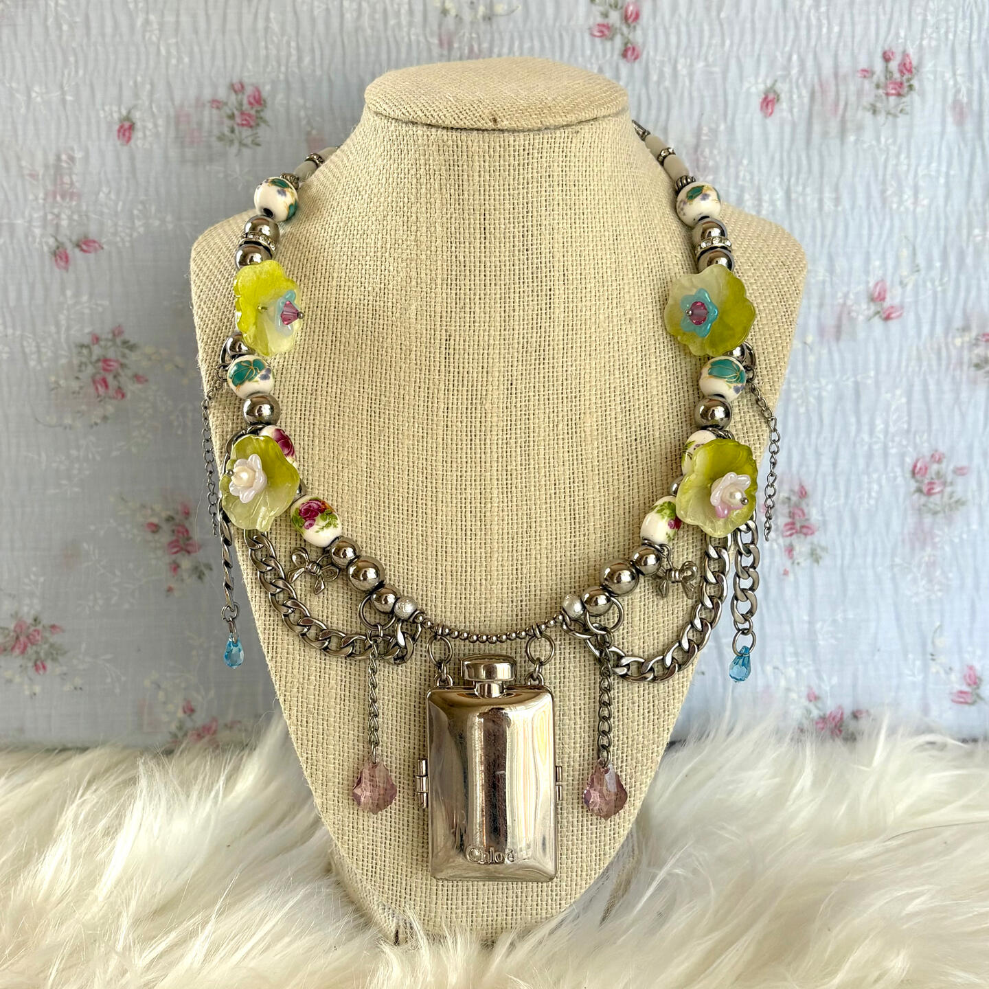 wear your sentimentality on your sleeve with this unique piece. featuring dozens of ornate porcelain beads, glass leaves + flowers, swarovski crystal drops, and of course, a marc jacob’s chloé perfume bottle ; repurposed into a fully functional locket.